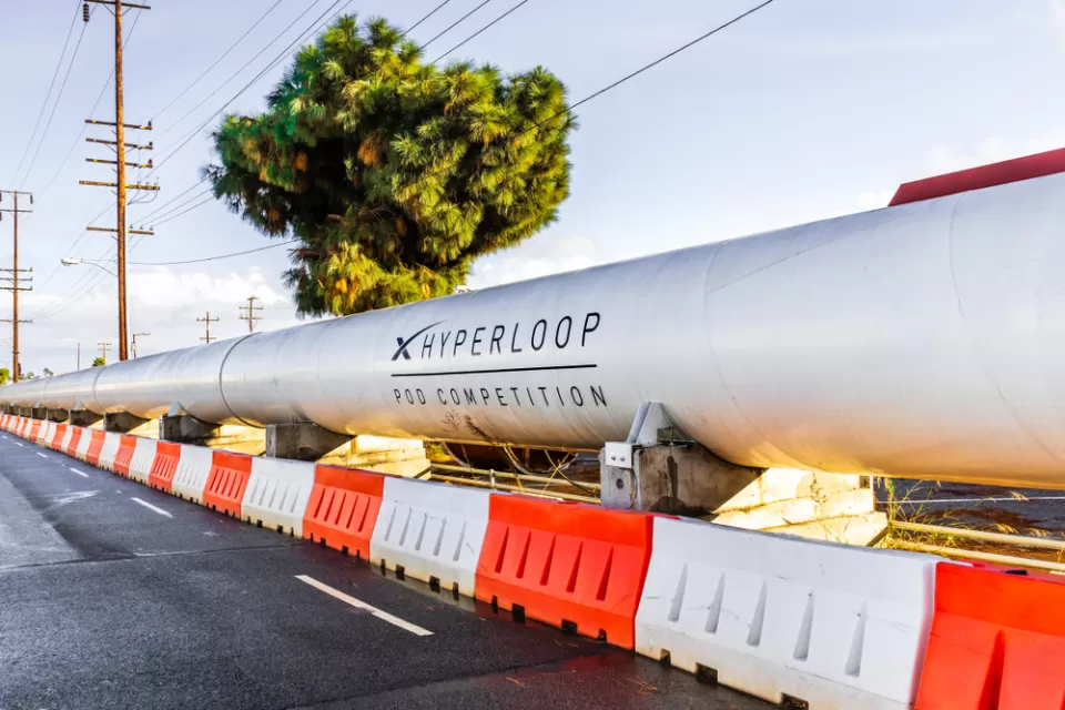 Hyperloop test tunnel on street with orange and white concrete barriers